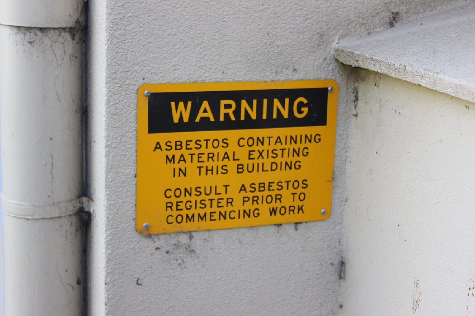A warning sign advising that asbestos containing material exists in the building and the register must be consulted before work
