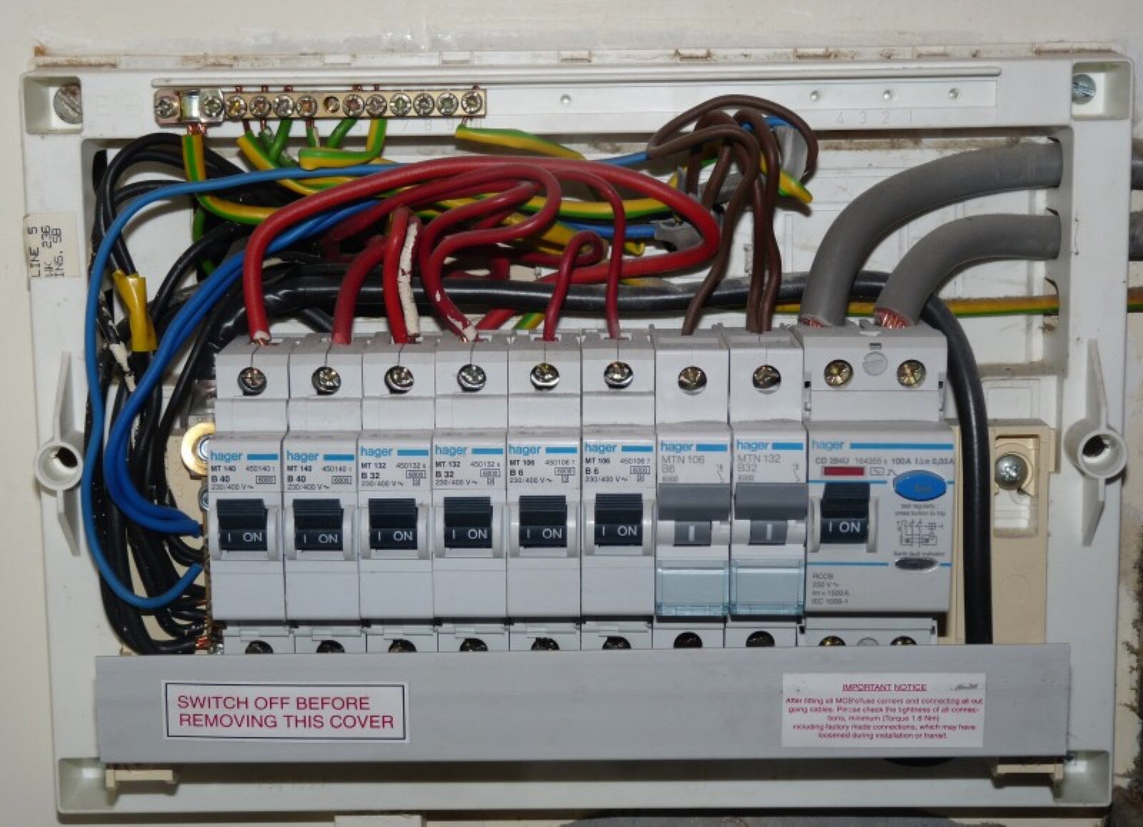 An open domestic consumer unit with circuit breakers, an RCD and coloured wiring visible